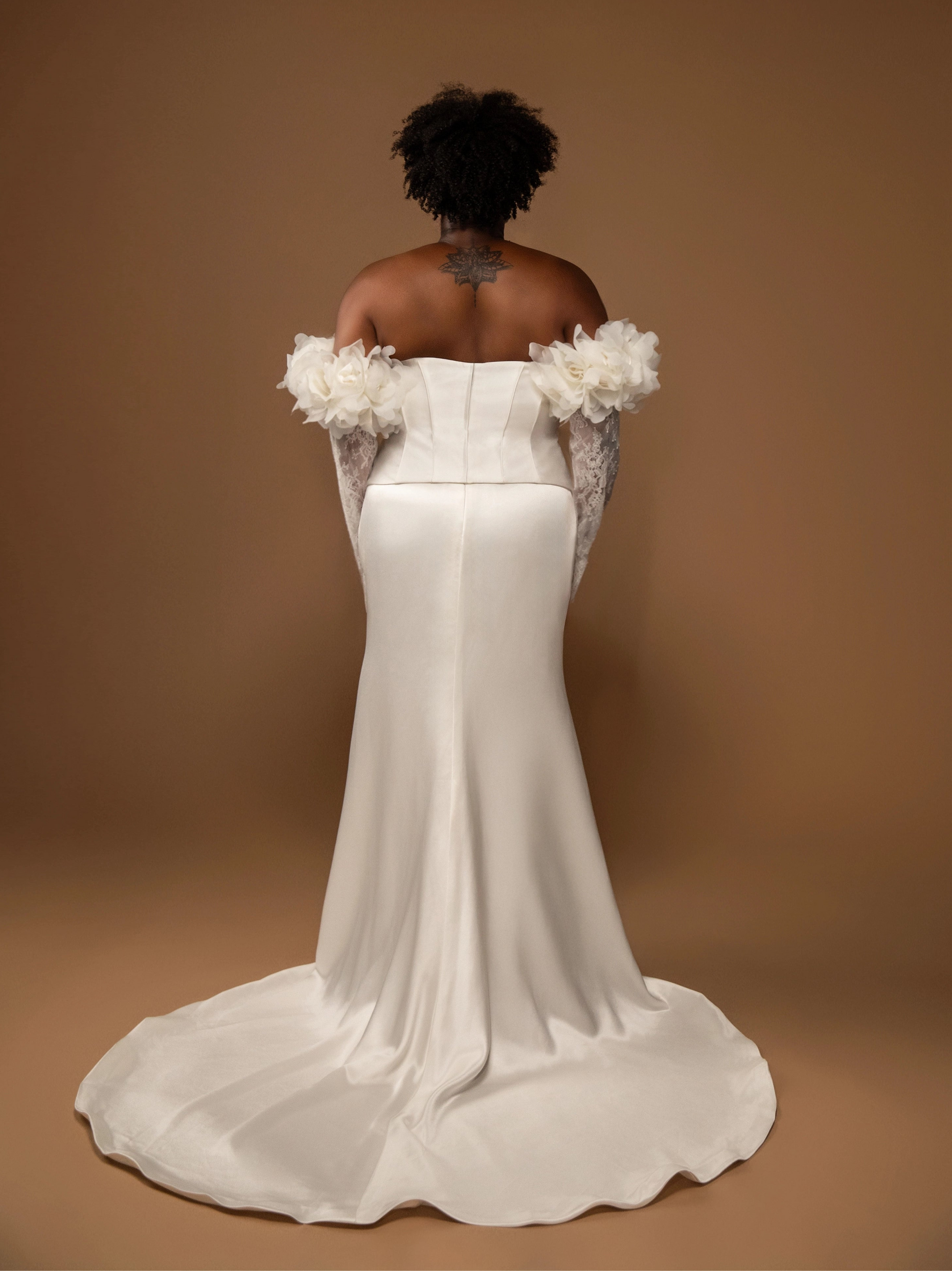 White off-shoulder wedding dress corset separates with floral details on a brown background plus size bride