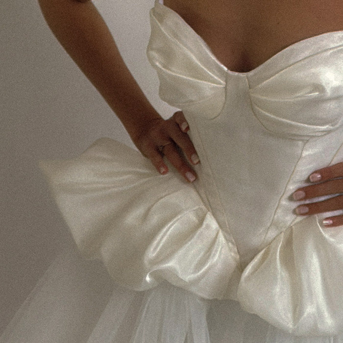 Close-up of a person wearing a white wedding dress 