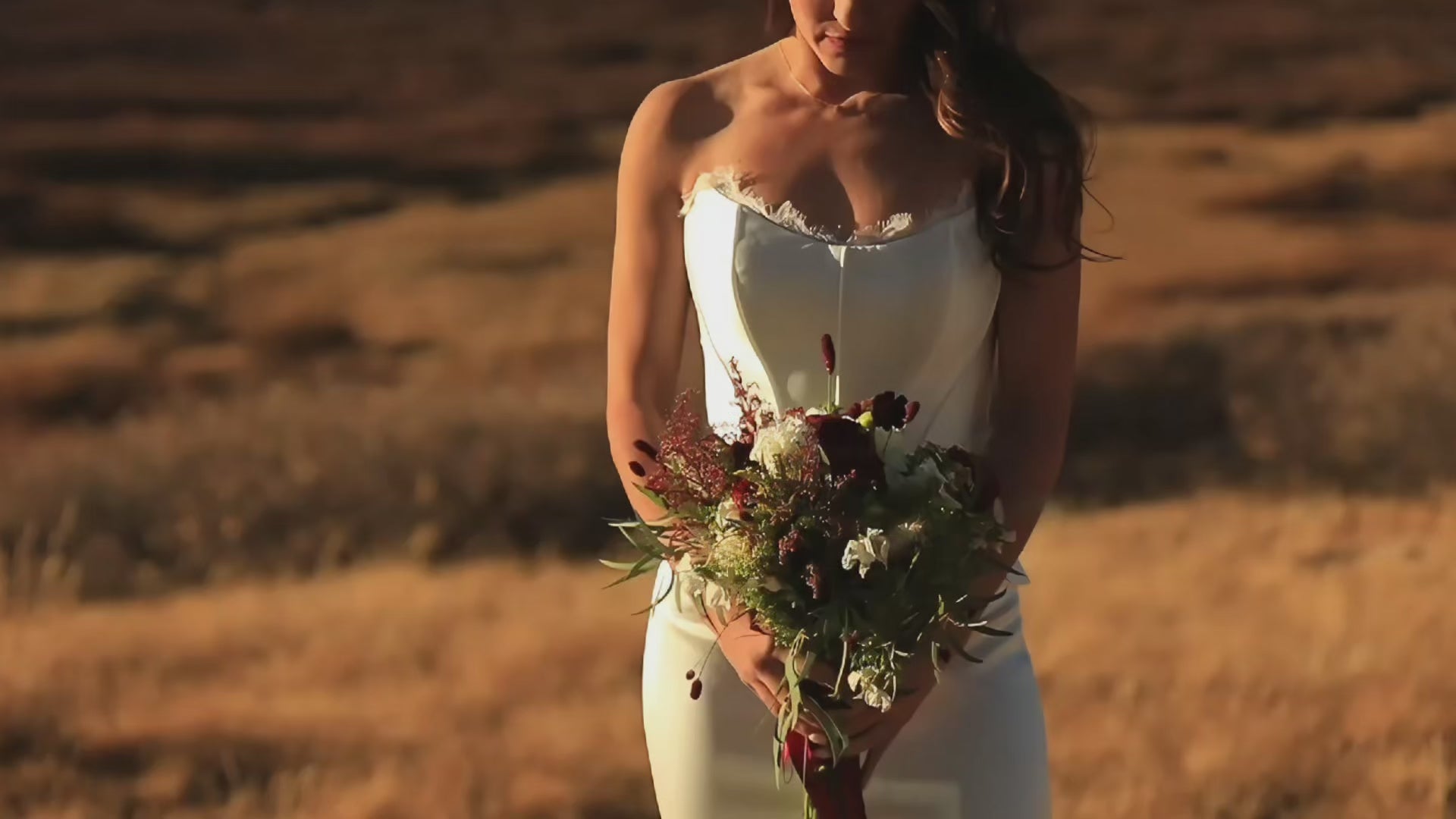 Load video: Bride in a modern minimalist wedding dress — the Evangeline — on a dreamy Colorado mountaintop with soft wind and sweeping Rocky Mountain views